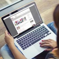 Frau mit Laptop stöbert im Online-Katalog der Stadtbibliothek Erlangen.