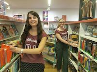 Eine frühere Auszubildende und eine früherer FSJlerin sortieren Medien zurück in die Regale der Kinderbibliothek.